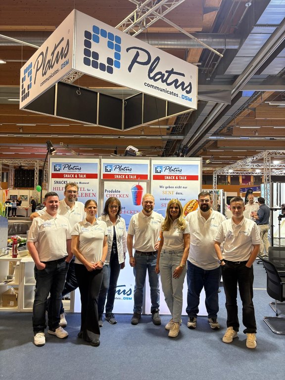 Messestand von Platus mit Sprachcomputern auf einem Tisch
