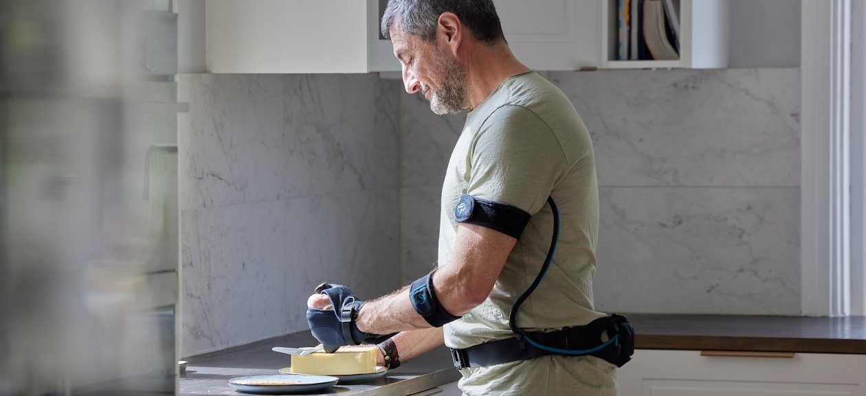 Ein Mann mit Carbonhand schneidet in der Küche einen Kuchen an